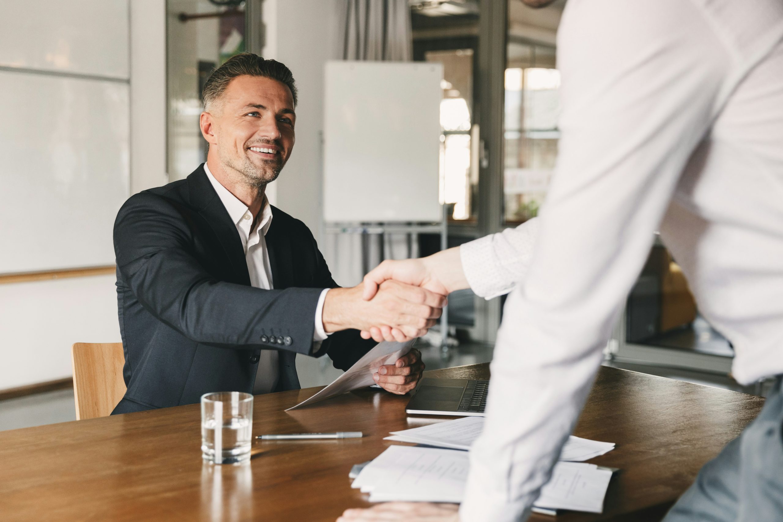 Image of franchise executive at table shaking hands with hiring manager