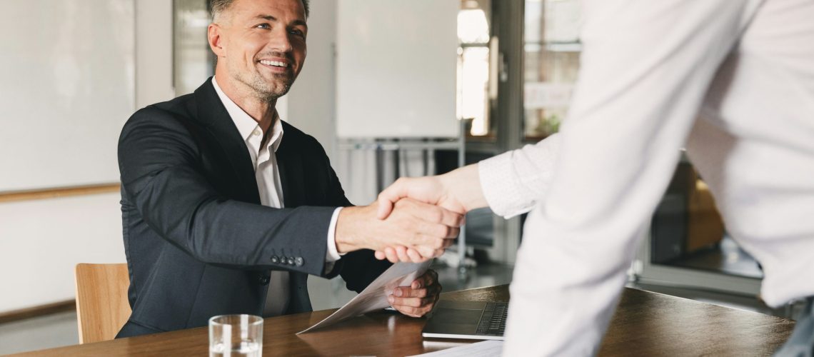 Image of franchise executive at table shaking hands with hiring manager